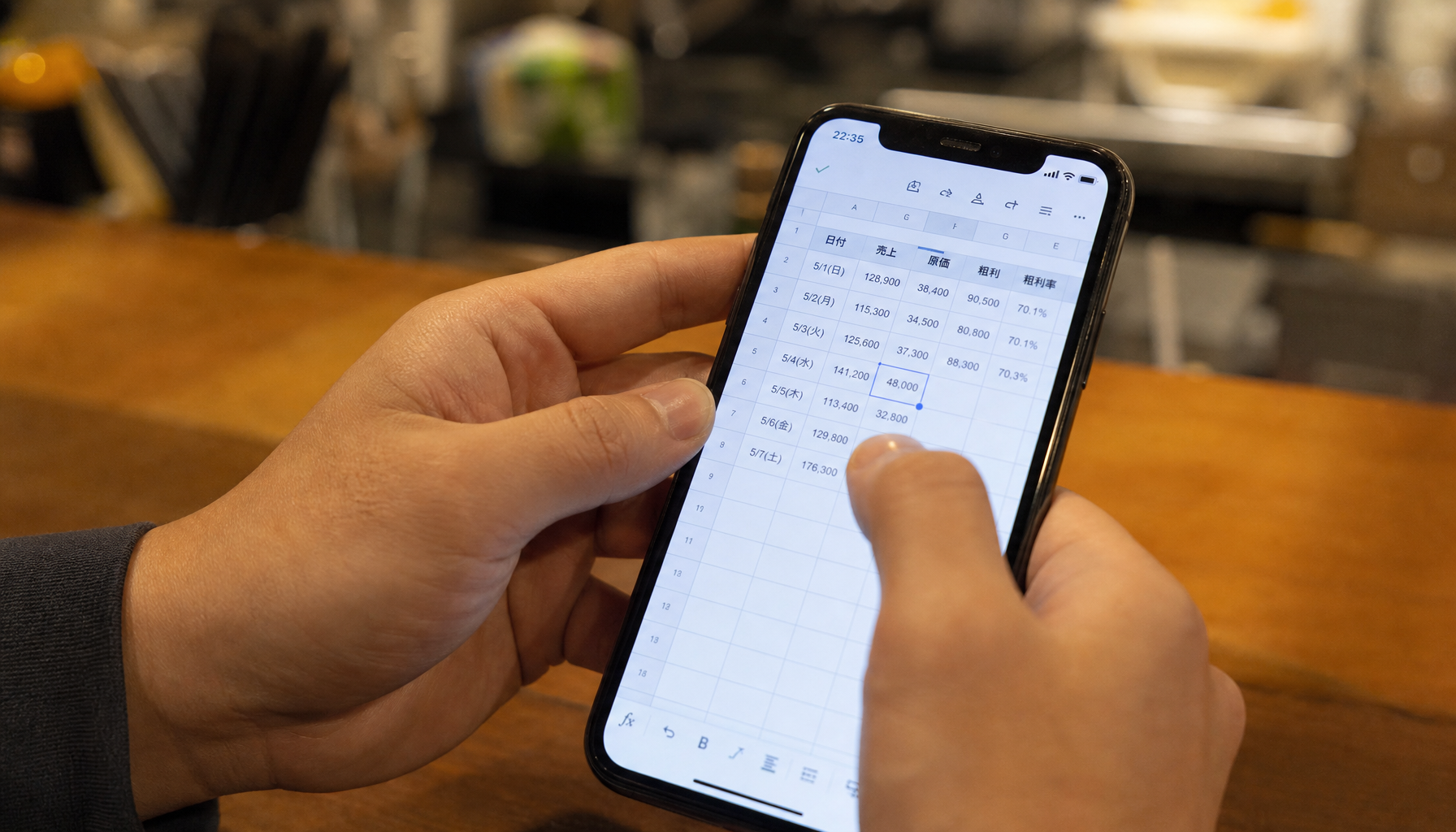 飲食店スタッフがスマホでGoogleスプレッドシートに売上を入力している手元の様子